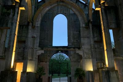 Salle équipée de plans de travail en inox, évier et carrelage gris, avec un panneau ’L'Eglise’ au mur.