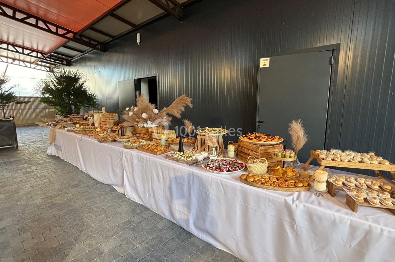 Buffet varié disposé sur de longues tables, comprenant des plats salés et sucrés dans un espace couvert.