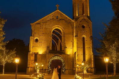 Salle équipée de plans de travail en inox, évier et carrelage gris, avec un panneau ’L'Eglise’ au mur.
