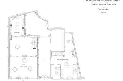 Homme portant une chemise blanche et une médaille, debout dans un environnement intérieur lumineux flou.