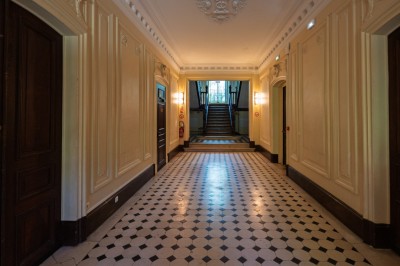 Miniature Hall d'entrée du rez-de-chaussée Trois tables hautes recouvertes de housses noires et blanches dans une pièce au parquet en chevrons et murs clairs.