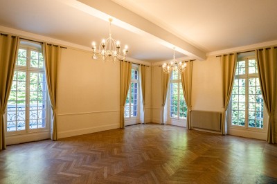 Miniature Salon Le Maitre de Forges Trois tables hautes recouvertes de housses noires et blanches dans une pièce au parquet en chevrons et murs clairs.