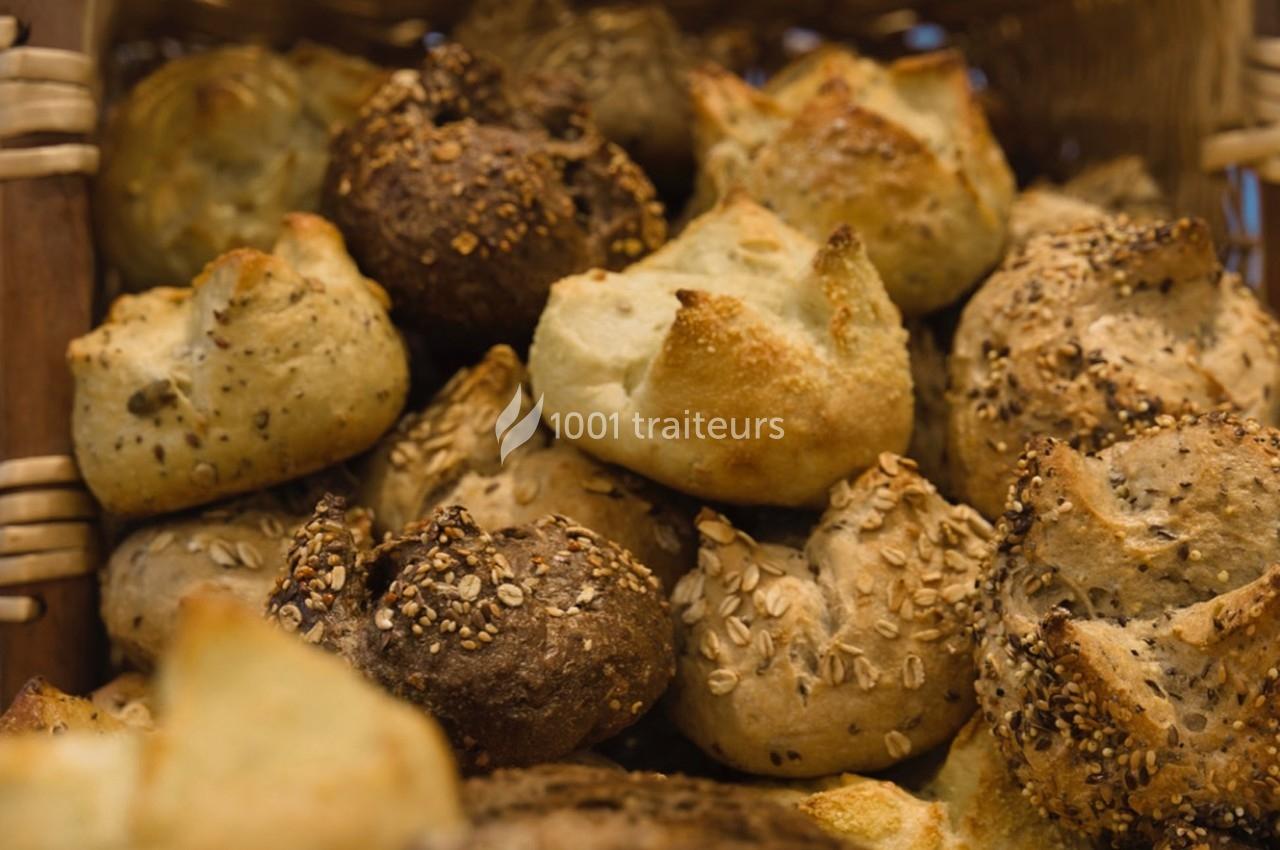 Assortiment de petits pains variés avec différentes graines, disposés dans un panier en osier.