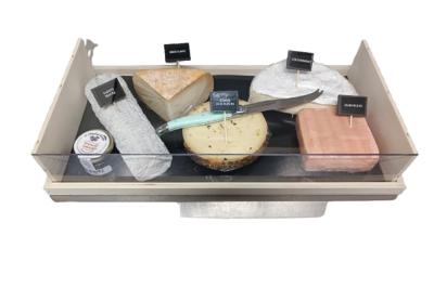 Plateau de fromages variés disposés sur un fond noir, incluant fromages à pâte dure, molle et persillée.