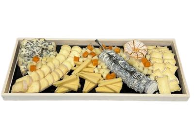 Plateau de fromages variés disposés sur un fond noir, incluant fromages à pâte dure, molle et persillée.
