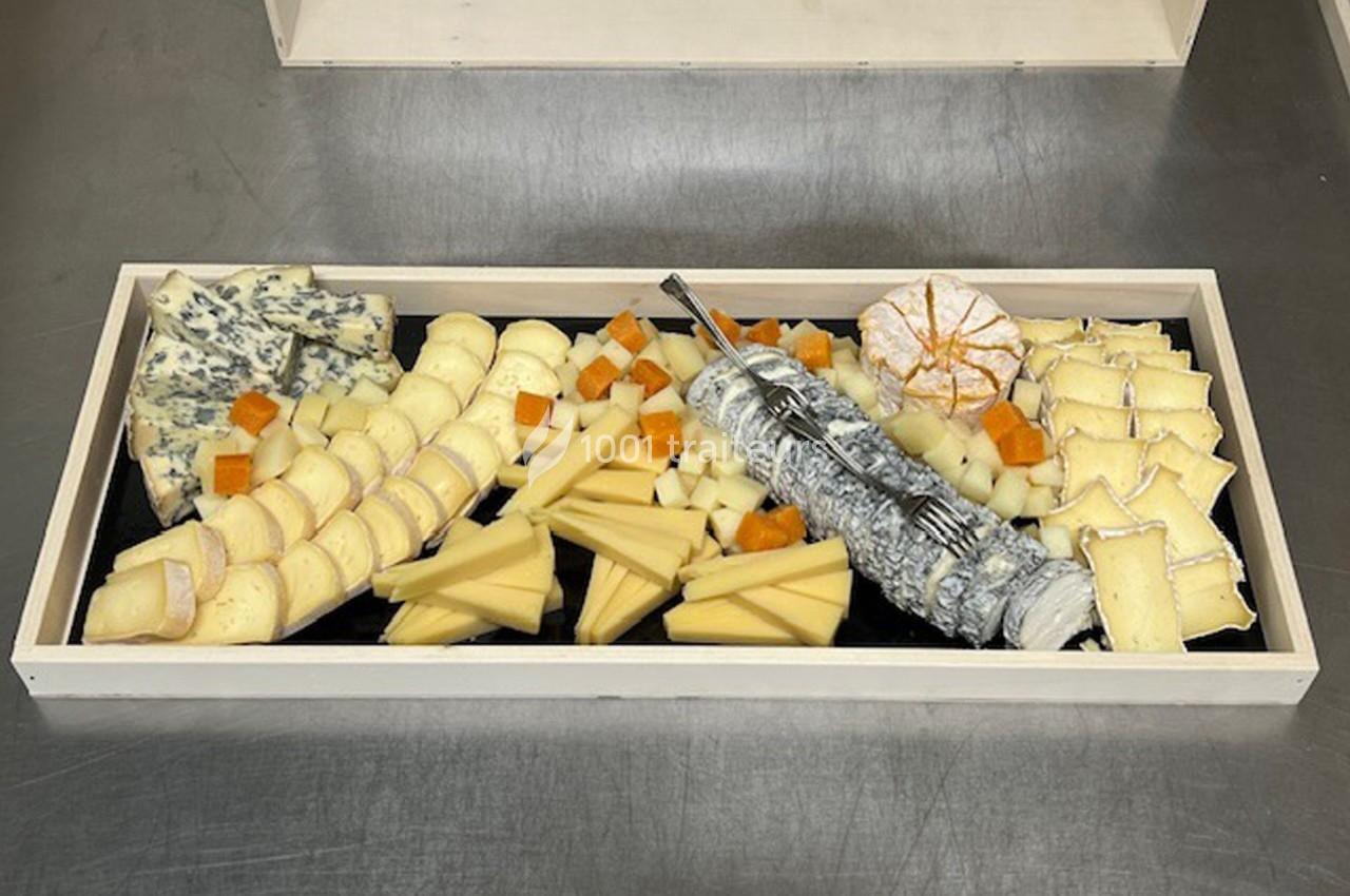 Plateau de fromages variés disposés sur un fond noir, incluant fromages à pâte dure, molle et persillée.