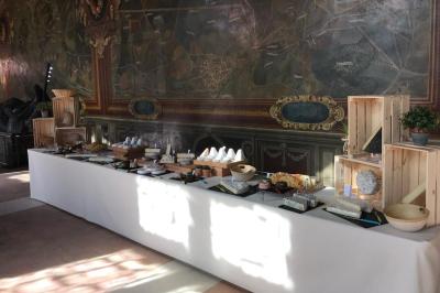 Table de buffet élégamment dressée avec divers fromages, présentée devant une fresque murale décorative.