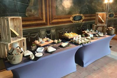 Plateau de fromages variés disposés en rangées, incluant fromages à pâte molle, dure, persillée et chèvre cendré.