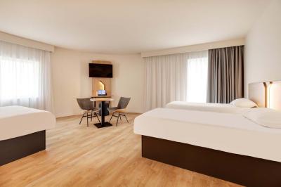 Salle de bain moderne avec douche à l'italienne, lavabo avec miroir éclairé et serviettes pliées sur une étagère.