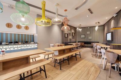 Salle de bain moderne avec douche à l'italienne, lavabo avec miroir éclairé et serviettes pliées sur une étagère.