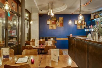 Deux choux farcis servis dans une assiette blanche avec une sauce brune, sur une table en bois.