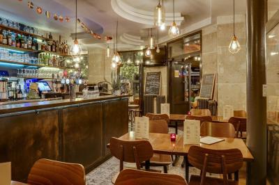 Deux choux farcis servis dans une assiette blanche avec une sauce brune, sur une table en bois.