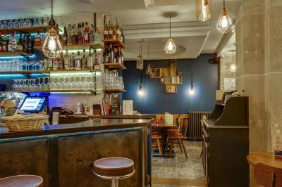 Deux choux farcis servis dans une assiette blanche avec une sauce brune, sur une table en bois.