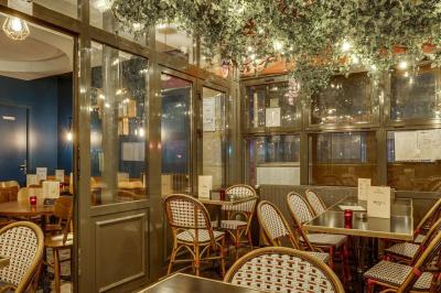Deux choux farcis servis dans une assiette blanche avec une sauce brune, sur une table en bois.