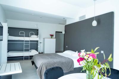 Deux chaises longues en métal avec serviettes roulées dans un espace spa, près d'un sauna en bois.