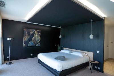 Deux chaises longues en métal avec serviettes roulées dans un espace spa, près d'un sauna en bois.