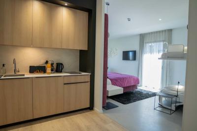 Deux chaises longues en métal avec serviettes roulées dans un espace spa, près d'un sauna en bois.