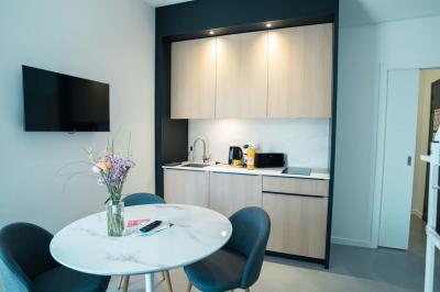 Deux chaises longues en métal avec serviettes roulées dans un espace spa, près d'un sauna en bois.