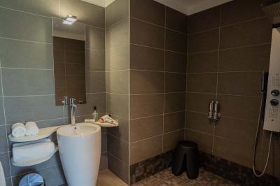 Deux chaises longues en métal avec serviettes roulées dans un espace spa, près d'un sauna en bois.