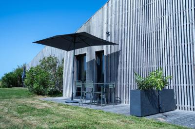 Deux chaises longues en métal avec serviettes roulées dans un espace spa, près d'un sauna en bois.