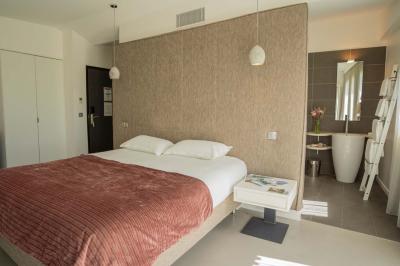 Deux chaises longues en métal avec serviettes roulées dans un espace spa, près d'un sauna en bois.