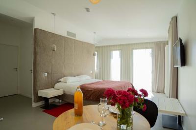 Deux chaises longues en métal avec serviettes roulées dans un espace spa, près d'un sauna en bois.