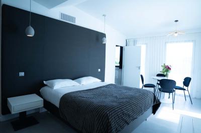 Deux chaises longues en métal avec serviettes roulées dans un espace spa, près d'un sauna en bois.