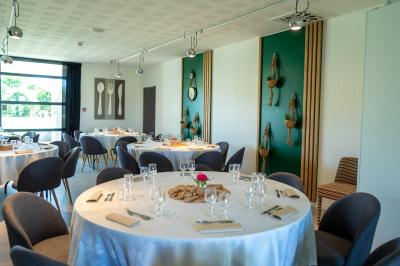 Deux chaises longues en métal avec serviettes roulées dans un espace spa, près d'un sauna en bois.