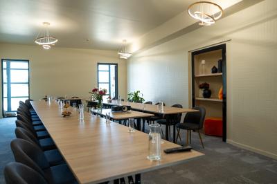 Deux chaises longues en métal avec serviettes roulées dans un espace spa, près d'un sauna en bois.