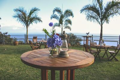 Vue sur une étendue d'océan au coucher du soleil, entourée de végétation verdoyante au premier plan.