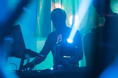 Scène décorée avec des guirlandes lumineuses, éclairages colorés et équipements audio dans une salle vide.