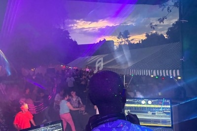 Scène décorée avec guirlandes lumineuses, éclairages colorés et équipements audio dans une salle intérieure.