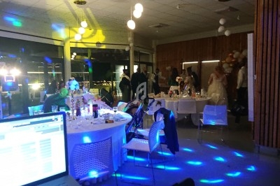 Scène décorée avec guirlandes lumineuses, éclairages colorés et équipements audio dans une salle intérieure.