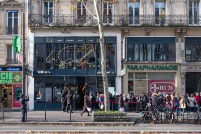Miniature Location salle Paris 10 (Paris) - La Scala Paris #1 Façade d'un théâtre et d'une parapharmacie sur une avenue parisienne, avec des passants et des vélos stationnés.