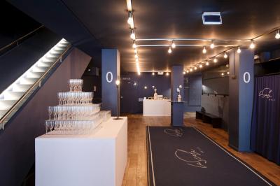 Foule rassemblée devant une façade vitrée illuminée avec le logo ’La Scala Paris’ visible à l'étage supérieur.