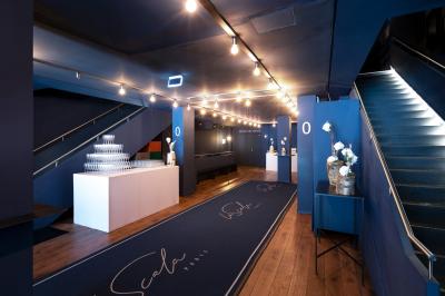 Foule rassemblée devant une façade vitrée illuminée avec le logo ’La Scala Paris’ visible à l'étage supérieur.