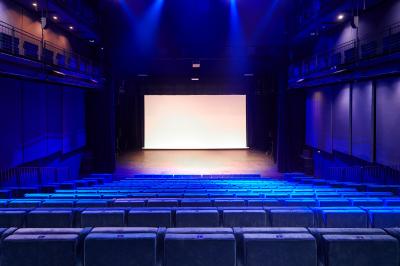 Foule rassemblée devant une façade vitrée illuminée avec le logo ’La Scala Paris’ visible à l'étage supérieur.
