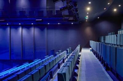 Foule rassemblée devant une façade vitrée illuminée avec le logo ’La Scala Paris’ visible à l'étage supérieur.