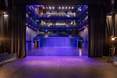 Foule rassemblée devant une façade vitrée illuminée avec le logo ’La Scala Paris’ visible à l'étage supérieur.