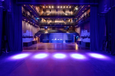 Foule rassemblée devant une façade vitrée illuminée avec le logo ’La Scala Paris’ visible à l'étage supérieur.