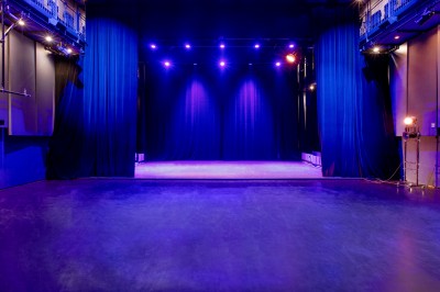 Foule rassemblée devant une façade vitrée illuminée avec le logo ’La Scala Paris’ visible à l'étage supérieur.