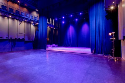 Foule rassemblée devant une façade vitrée illuminée avec le logo ’La Scala Paris’ visible à l'étage supérieur.