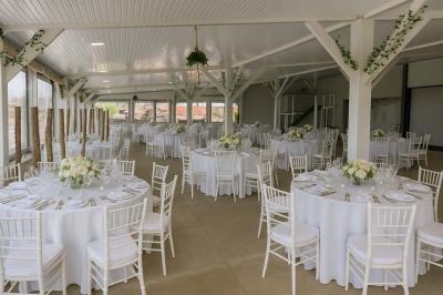 Un couple de dos, debout sur une plage, tenant la main, face à la mer sous un ciel dégagé.