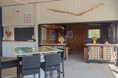 Un couple de dos, debout sur une plage, tenant la main, face à la mer sous un ciel dégagé.