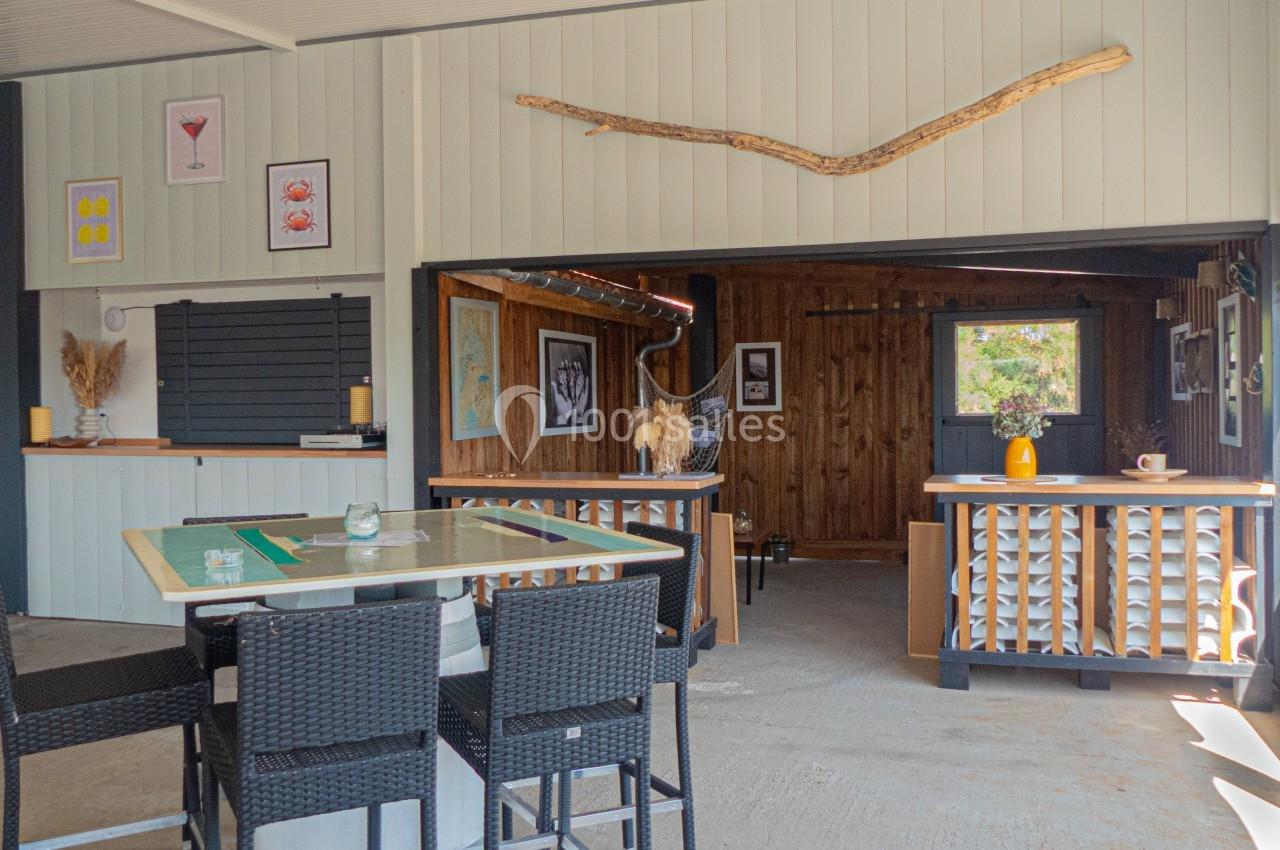 Espace intérieur lumineux avec mobilier en rotin, décoration murale et comptoir en bois dans un style rustique.