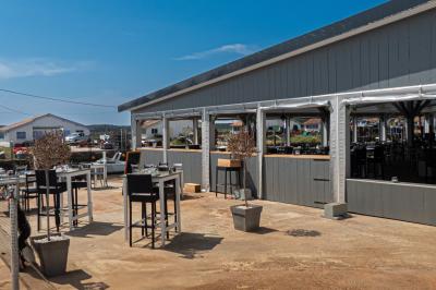 Un couple de dos, debout sur une plage, tenant la main, face à la mer sous un ciel dégagé.