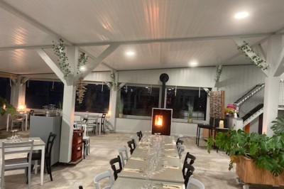 Un couple de dos, debout sur une plage, tenant la main, face à la mer sous un ciel dégagé.