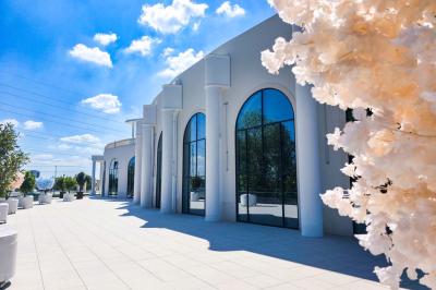 Lustre en cristal doré suspendu sous un plafond peint avec des nuances pastel de bleu et de rose.