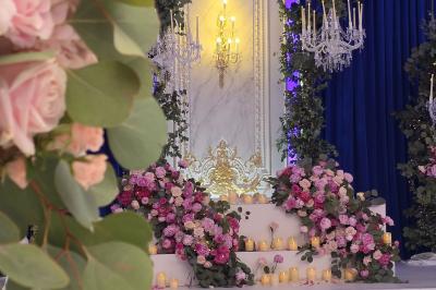 Lustre en cristal doré suspendu sous un plafond peint avec des nuances pastel de bleu et de rose.