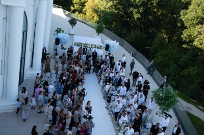 Lustre en cristal doré suspendu sous un plafond peint avec des nuances pastel de bleu et de rose.